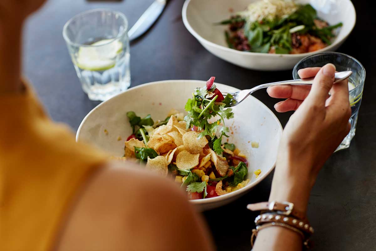 Kvinna som äter en sallad på en restaurang